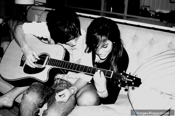 couple-playing-guitar-on-sofa-affection
